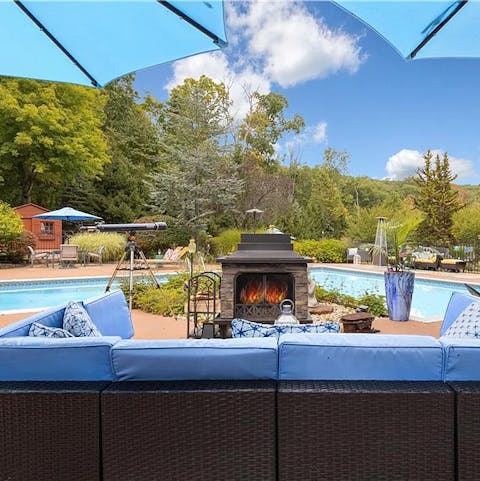 Gather around the outdoor fireplace by the poolside