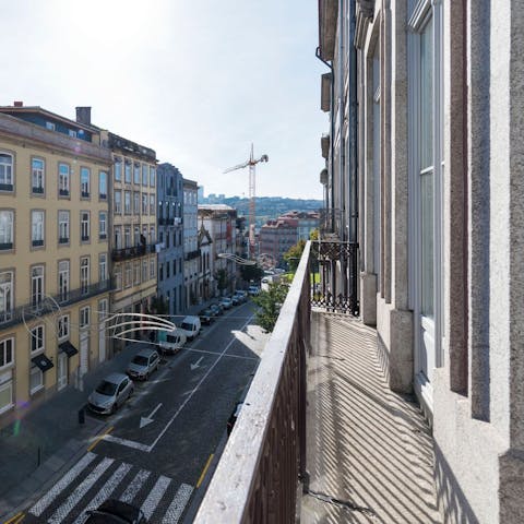 Step out onto your private balcony and watch people bustle  along the pavement below