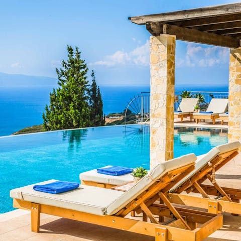 Laze on luxe loungers beside the pool while gazing out to sea