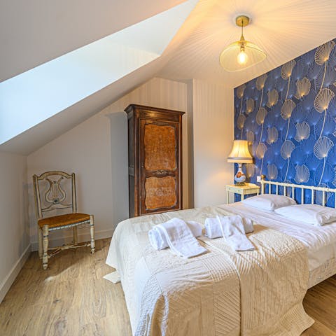 Wake up in an elegantly Art Deco-styled bedroom beneath sloped ceilings