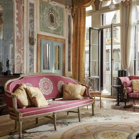 Relax on the elegant sofa surrounded by painted frescoes bathed in light