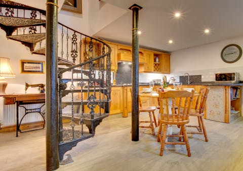 Descend this spiral staircase and make breakfast in a warm-wooded kitchen