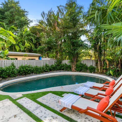 Recline by the heated pool in the lush garden