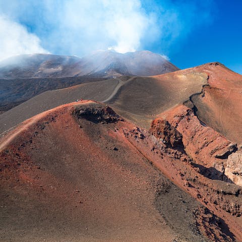 Hike up the steep slopes of Mount Etna, approximately an hour away