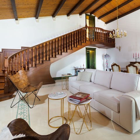 Kick back in the elegant living room beside the striking wood staircase