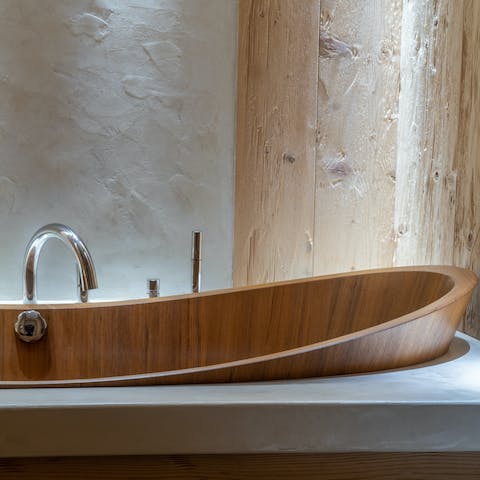 Treat yourself to a soak in the irresistibly elegant wooden bathtub