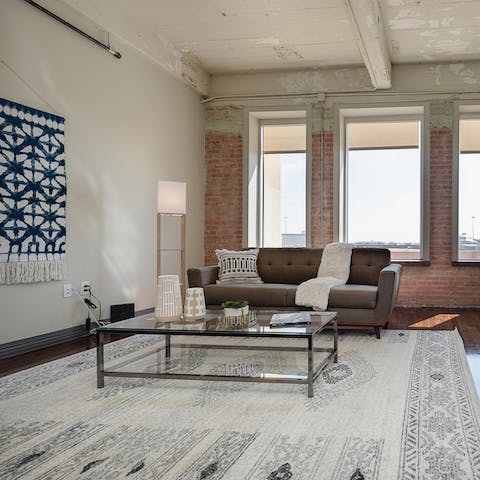 Kick back in the bright living room with an ice-cold drink while admiring your home's industrial aesthetic