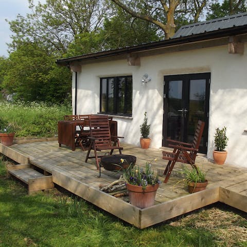 Relax on the wooden deck with a well-thumbed book or a refreshing cocktail