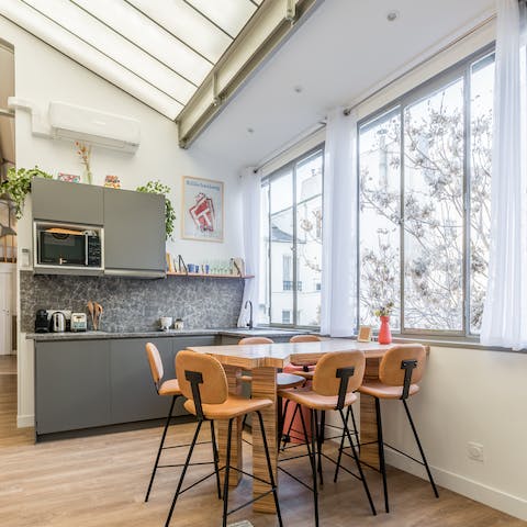 Sit down to a meal at the beautiful free-form dining table in the bright kitchen