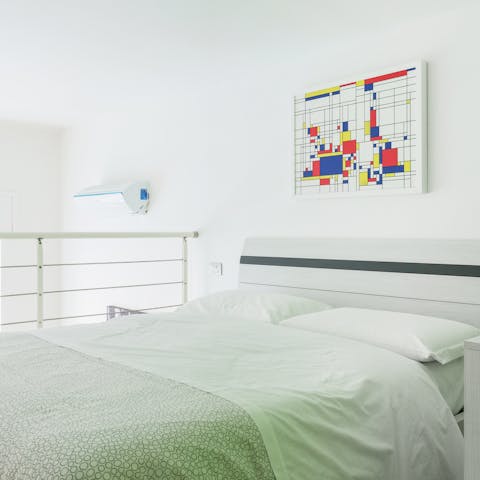 Get a restful night's sleep on the mezzanine bedroom with Mondrian-style prints