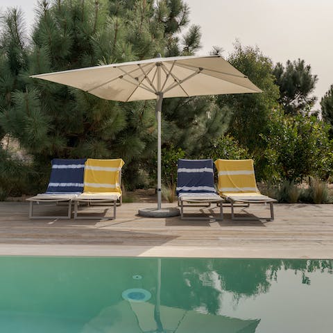 Splash about in the home's swimming pool before retiring to a lounger