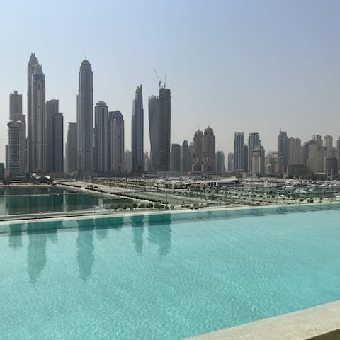 Swim in the glistening communal pool, surrounded by skyscrapers