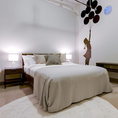 Drift off to dreamland in the sumptuous bedroom – we like the Banksy-style mural