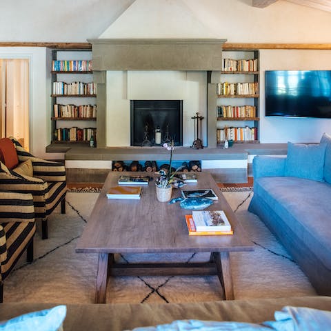 Pick a book off the shelf and sink into the sofa around the fireplace