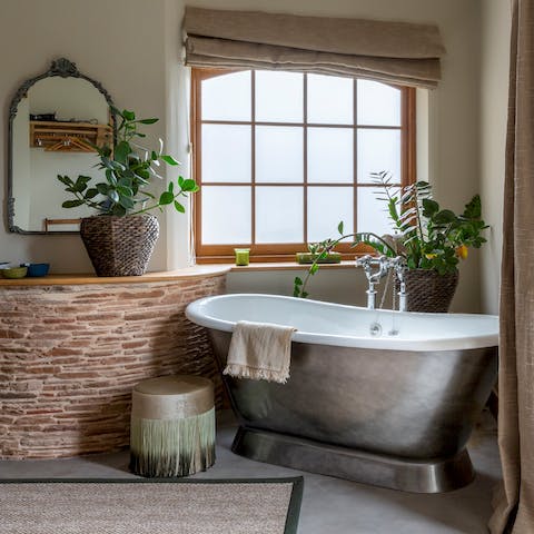 Unwind after a day at the beach with a relaxing soak in the main bedroom's lavish roll-top bath