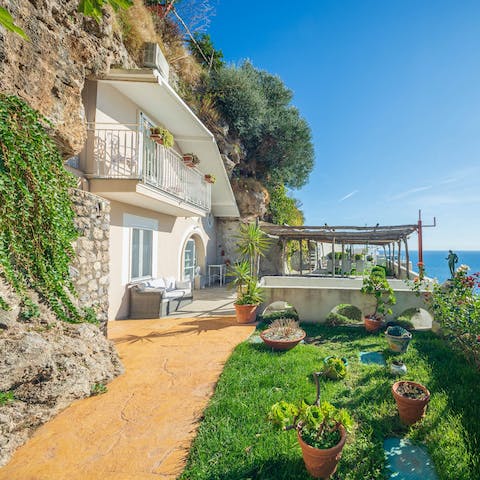 Gather for a sea-facing barbecue beneath the wooden pergola