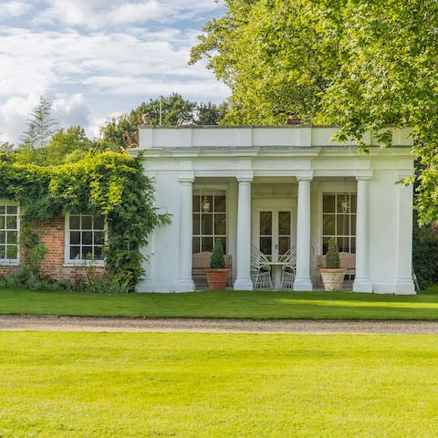 Take a seat on the porticoed patio and admire the gardens