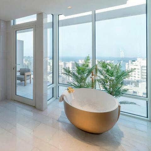 Unwind in the bathtub with the sparkling seascape as your backdrop 