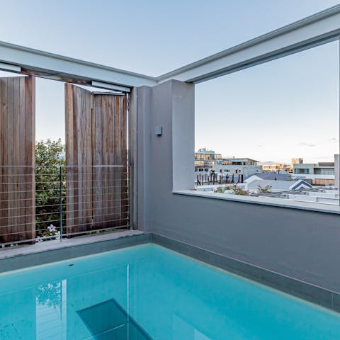 Open the living area's glass doors to reveal a splash pool with scenic picture window views