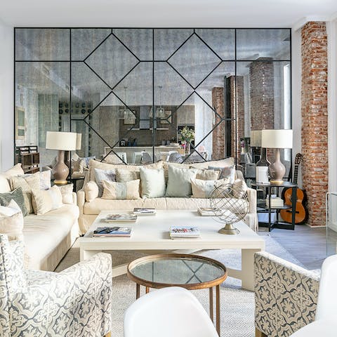 Relax in the comfortable living room with the striking mirrored wall