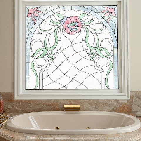A stained glass window above the spa bathtub  