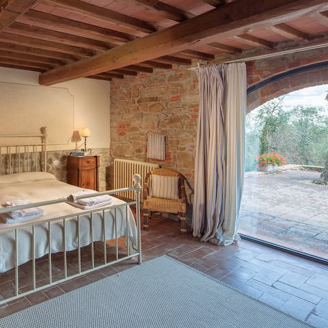 Wake up under traditional wood beams and invite the sunlight in through the huge curved window