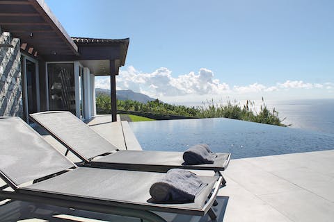 Spend your days lounging by the infinity pool and watching the sunlight dance on the sea ahead