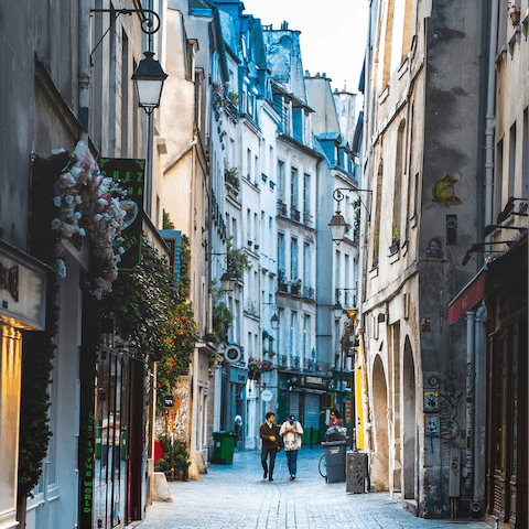 Explore Le Marais' narrow streets lined with vintage shops and cafes, a twenty-minute walk away