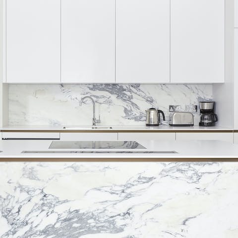 Plate up home-cooked perfection in the sleek marble-clad kitchen