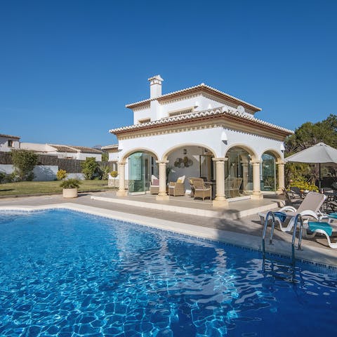 Sun yourself by the rippling waters of the villa's private pool