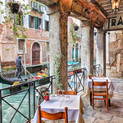 Sample Venice's local cuisine in a canal-front restaurant, just steps away