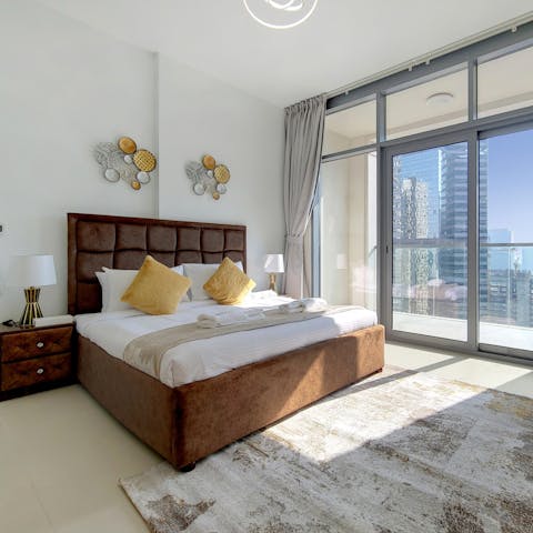 Enjoy views of the city through the floor-to-ceiling windows from the bed