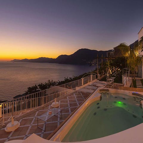Watch the sun set over the sea, with a glass of wine in-hand from the enormous hot tub 