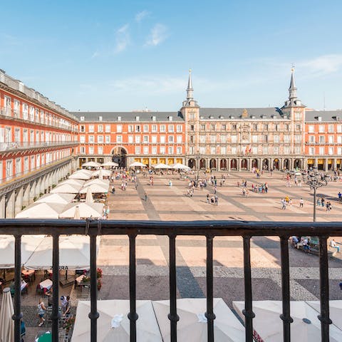 Watch people bustle around the Plaza Mayor from your balcony