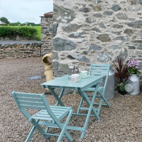 Sip tea on the shingle patio to the front of the cottage