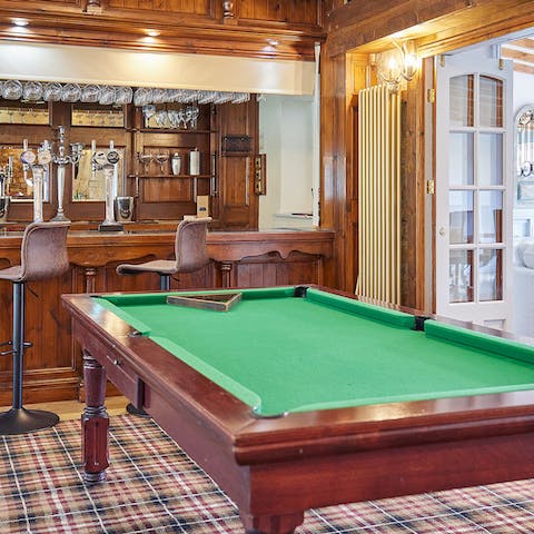 Play a spot of pool in the living room before mixing up cocktails in the bar