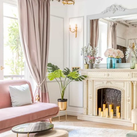 Stretch out on the pastel pink sofa and open some French wine