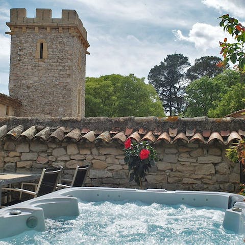 Unwind in the bubbling private Jacuzzi with views of the medieval tower