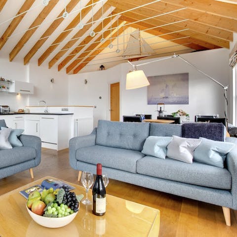 Kick back and relax on the sofa beneath beautiful beamed ceilings in the open plan living room 