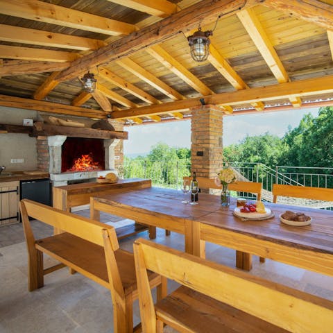 Light the fire in the outdoor kitchen and dining area for an evening meal