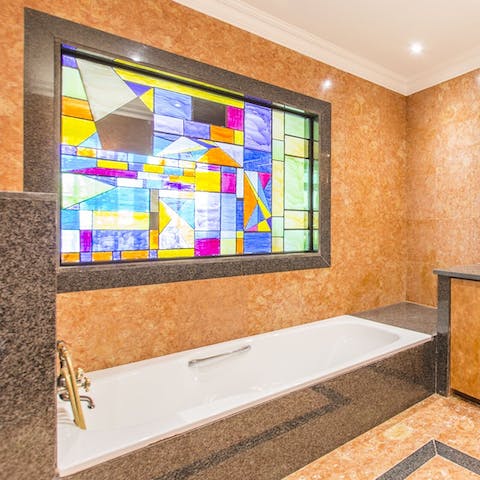 Sink into the bathtub and admire the stained glass as you soak