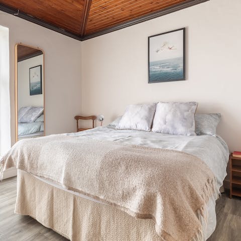 Sleep soundly beneath the beautiful wooden ceiling in the tranquil master bedroom