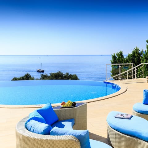 Sip cocktails on the pool terrace with direct sea views