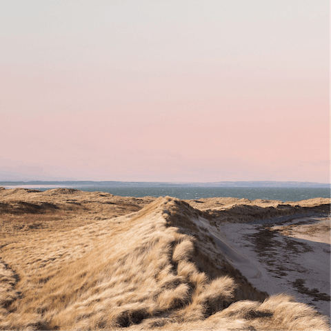 Take a stroll along the sandy dunes of Bamburgh Beach, less than a mile away