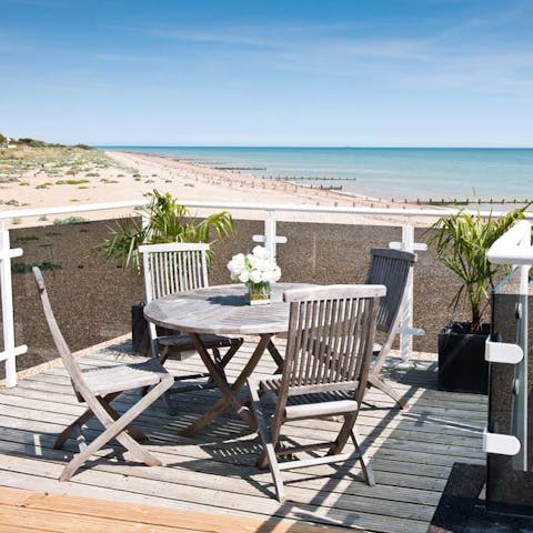 Enjoy a glass of English sparkling wine on the sunny terrace overlooking the beach