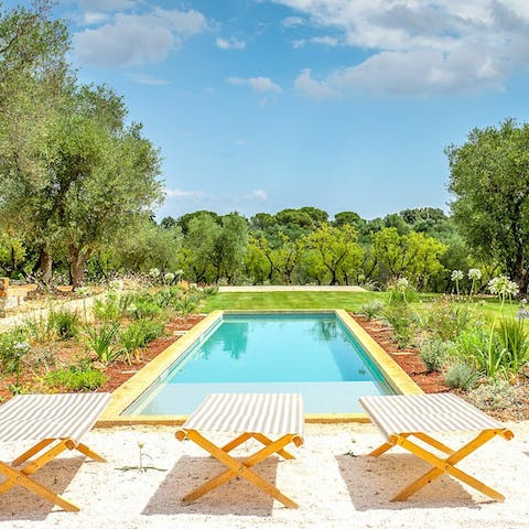 Lay out on a lounger by the pool, surrounded by vibrant organic gardens