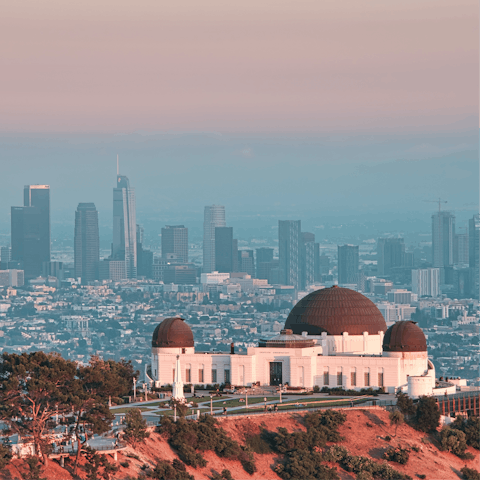 Visit the Griffith observatory as the sun begins to go down over the city
