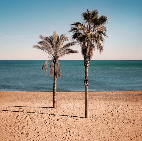 Sink your toes in the sand at Platja de la Mar Bella, easily reachable on foot