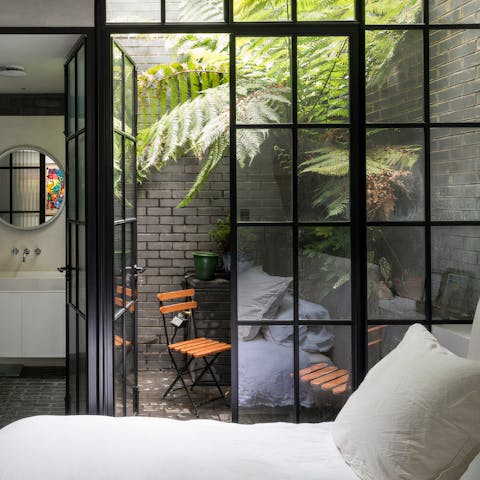 Wake up to leafy courtyard views in the chic bedroom