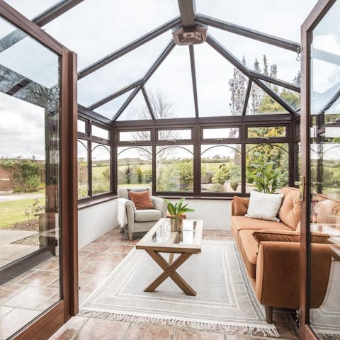 Relax in the luminous conservatory with a cup of tea in hand 